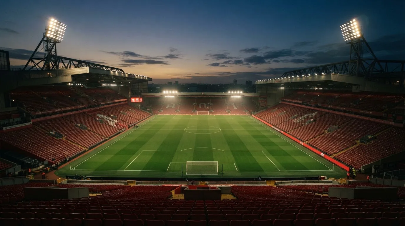 An empty football stadium with floodlight masts at dusk