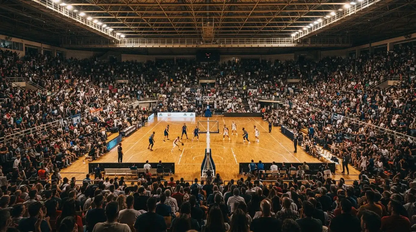 A packed sports hall under floodlights photographed from a long way off