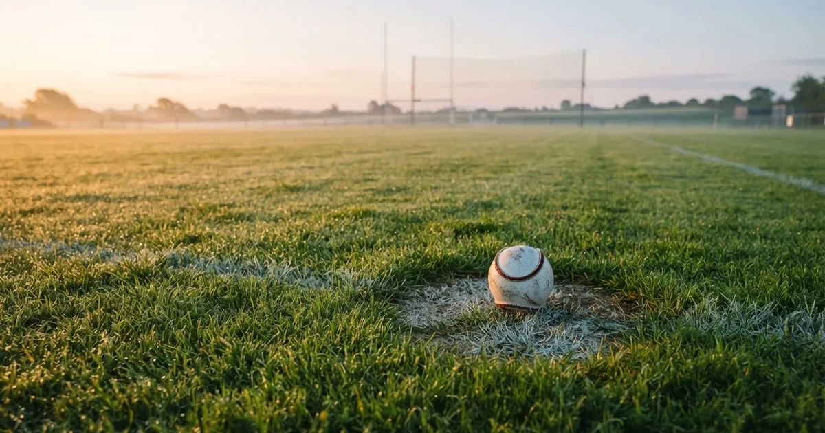 A ball on the centre spot of a grass pitch in morning light