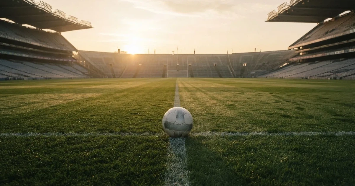 A ball on the centre spot of a grass pitch in morning light